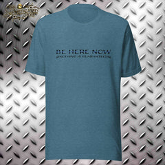 Teal t-shirt with "Be here now" caption and a thin blue line above caption "Nothing is guaranteed" with a skull at each end of the text